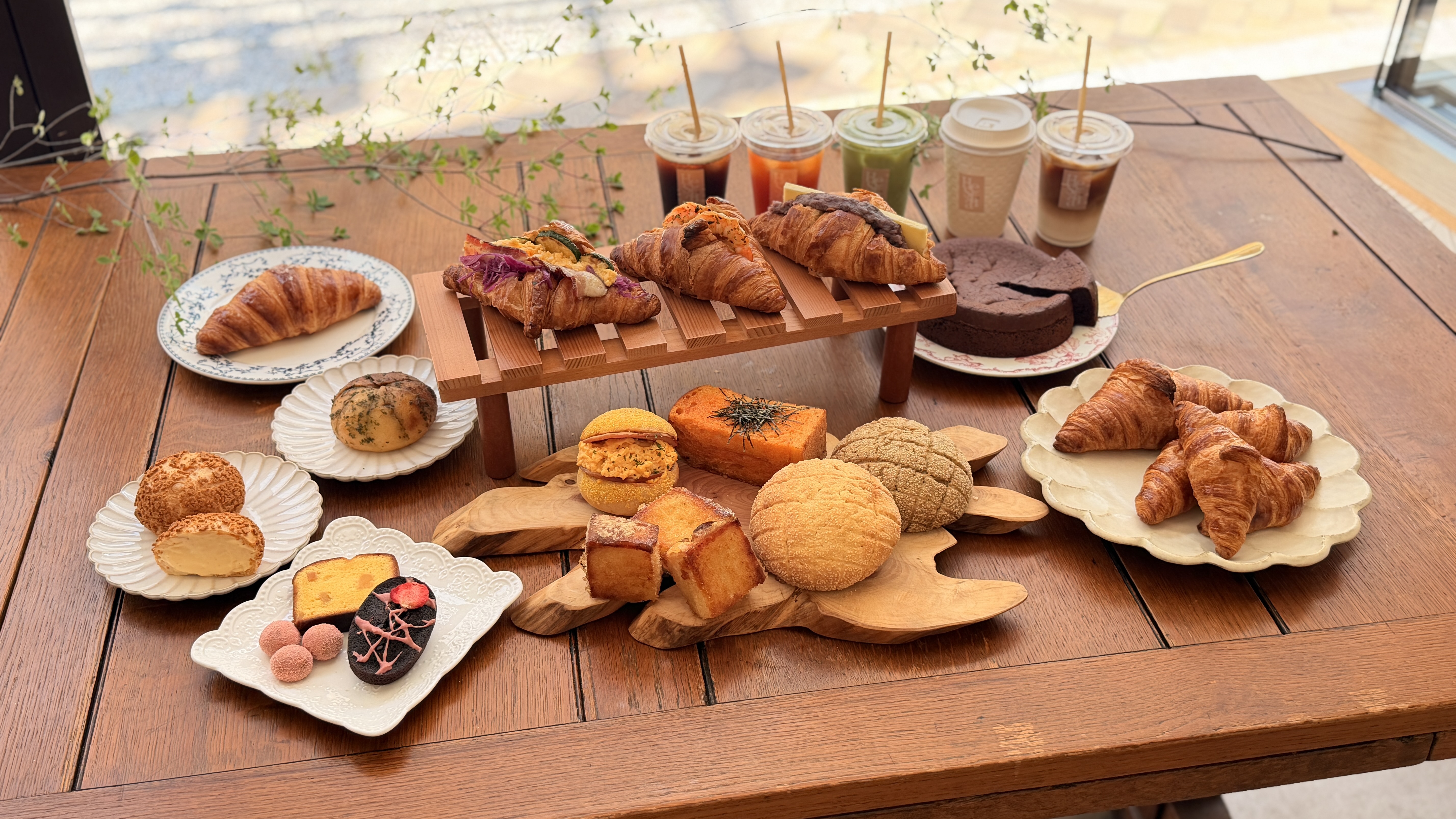 窓辺の木のテーブルを彩るMaison Hestiāのパンとお菓子